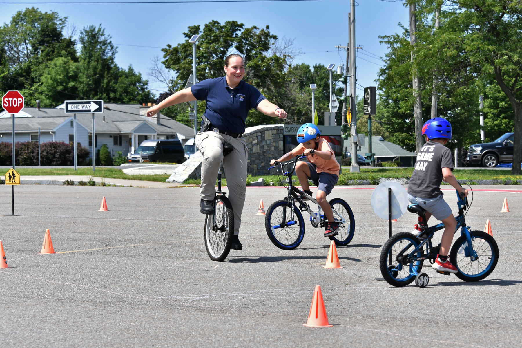 University Police Officer Tina Bedard skillfully rides a unicycle along with the kids on their bikes along the course during the Aug. 2 community bike rodeo.