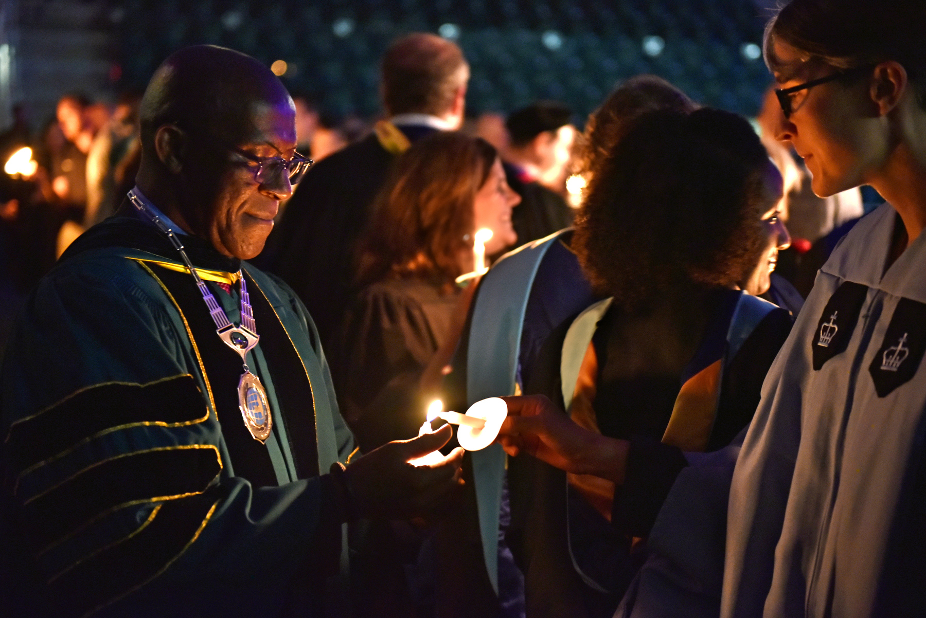 At the Welcoming Torchlight Ceremony, President Peter O. Nwosu lights the candle of Kristi Eck, Chief of Staff and Executive Director of Strategic Initiatives, External Partnerships and Legislative Affairs.