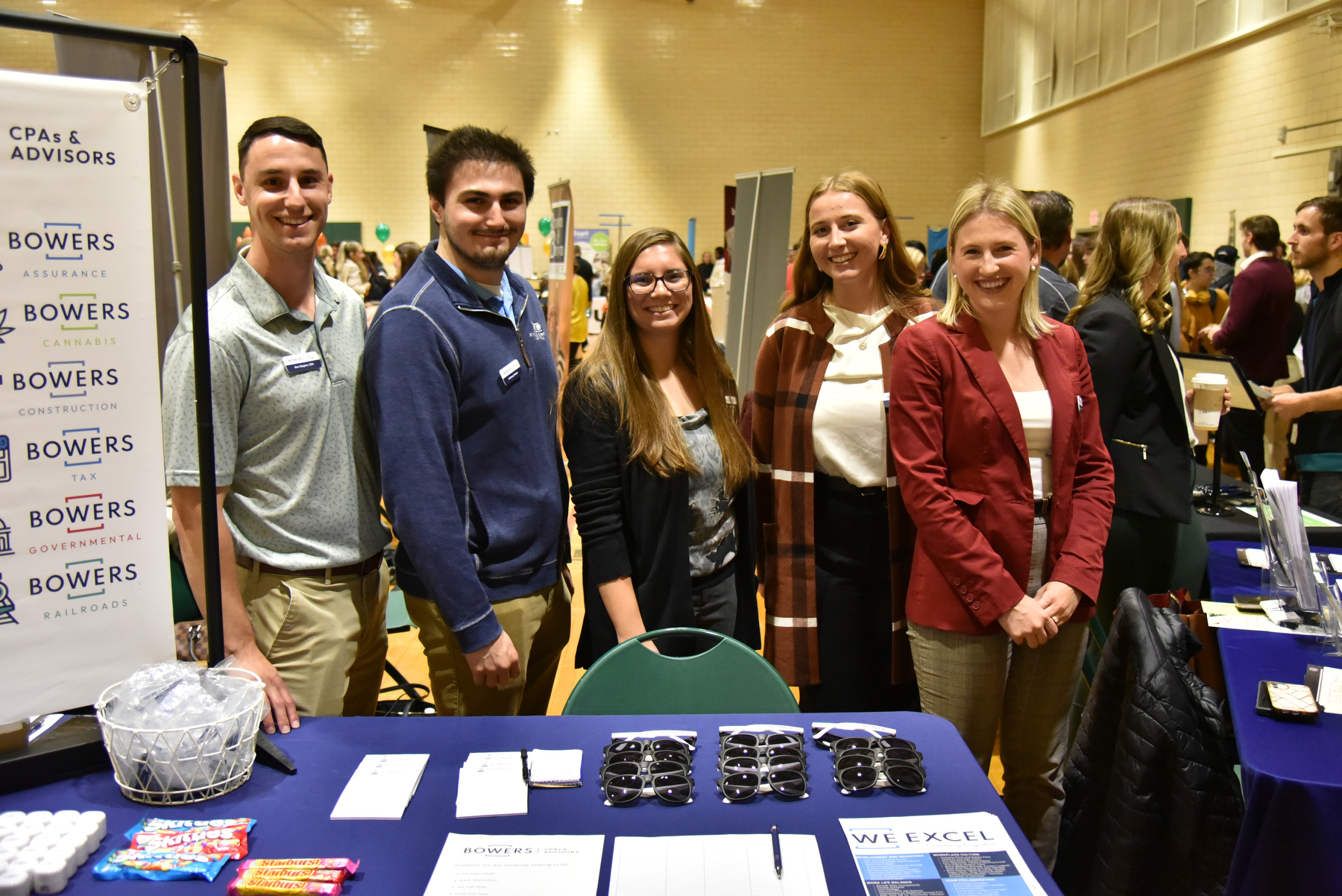 Among the 100+ professional representatives attending the Fall 2023 Career and Internship Fair were many Oswego alumni. From left are 2021 graduates Ben Mayers, Anthony Noteso and Ashley Edwards, and 2023 graduate Abigail Testo, all now employed with Bowers Company. The Oct. 18 event was hosted by Career Services and held in the Swetman Gym in the Marano Campus Center.