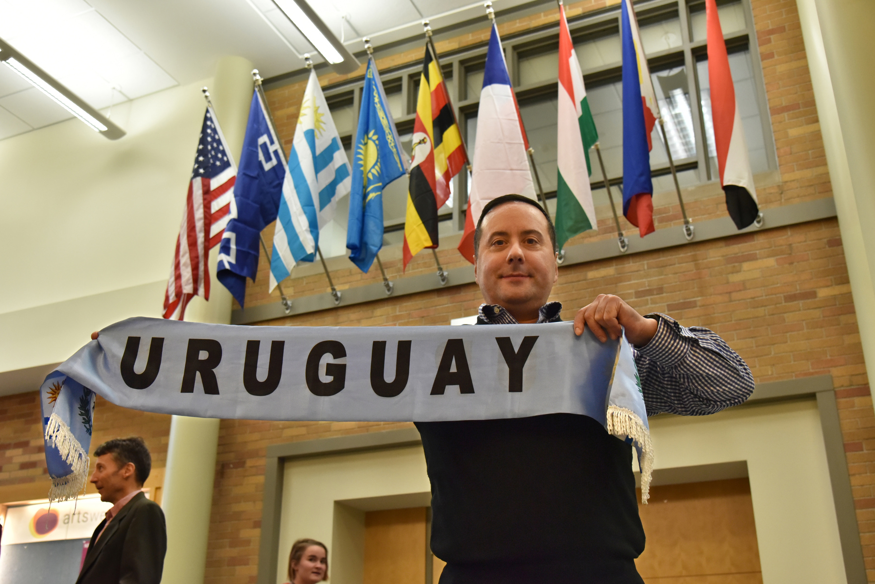 A Flags of Nations reception was held to recognize the updated additions to SUNY Oswego's Flags of Nations display located along the Marano Center concourse. The ceremony recognized the addition of flags representing the Haudenosaunee Confederacy and the countries of Chile, Uganda, Kazakhstan and Uruguay to the display. Pictured is Gonzalo Aguiar Malosetti, a modern languages and literatures faculty member, representing Uruguay near the display.