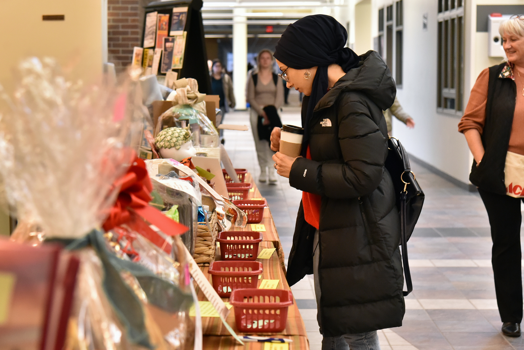 The annual Baskets of Caring fundraiser held Nov. 14 and 15 by the State Employees Federated Appeal committee raised nearly $4,000 for the United Way of Greater Oswego County. The event featured 16 themed baskets put together by members of the campus community. Busra Altay (pictured), a graduate student in the master of business administration program, casts votes toward baskets for chances to win.