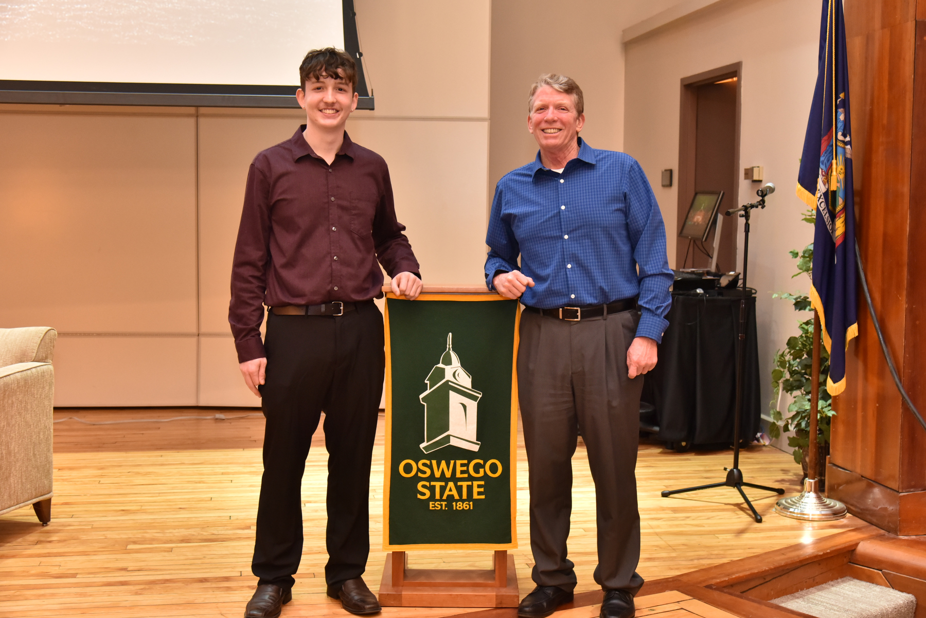 Graduate Bryan Morano takes photos with his dad Kevin at the Commencement Eve Reception held Dec. 15 in Sheldon Hall ballroom.