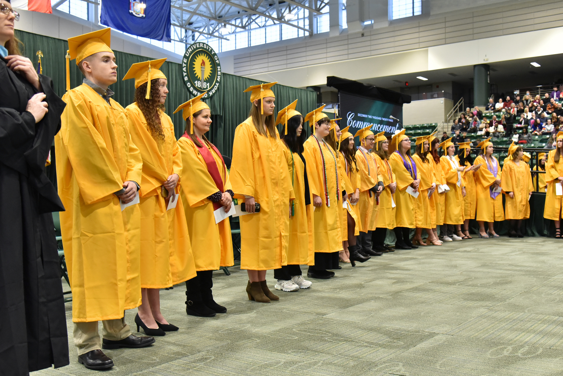 SUNY Oswego's December 2023 Commencement ceremony honored hundreds of undergraduates and graduate students in front of family, friends and supporters in the Deborah F. Stanley Arena and Convocation Hall in Marano Campus Center. Honors graduates – those graduating summa cum laude with grade-point averages of 3.8 or higher – line the front the stage as graduates and members of the platform party enter.