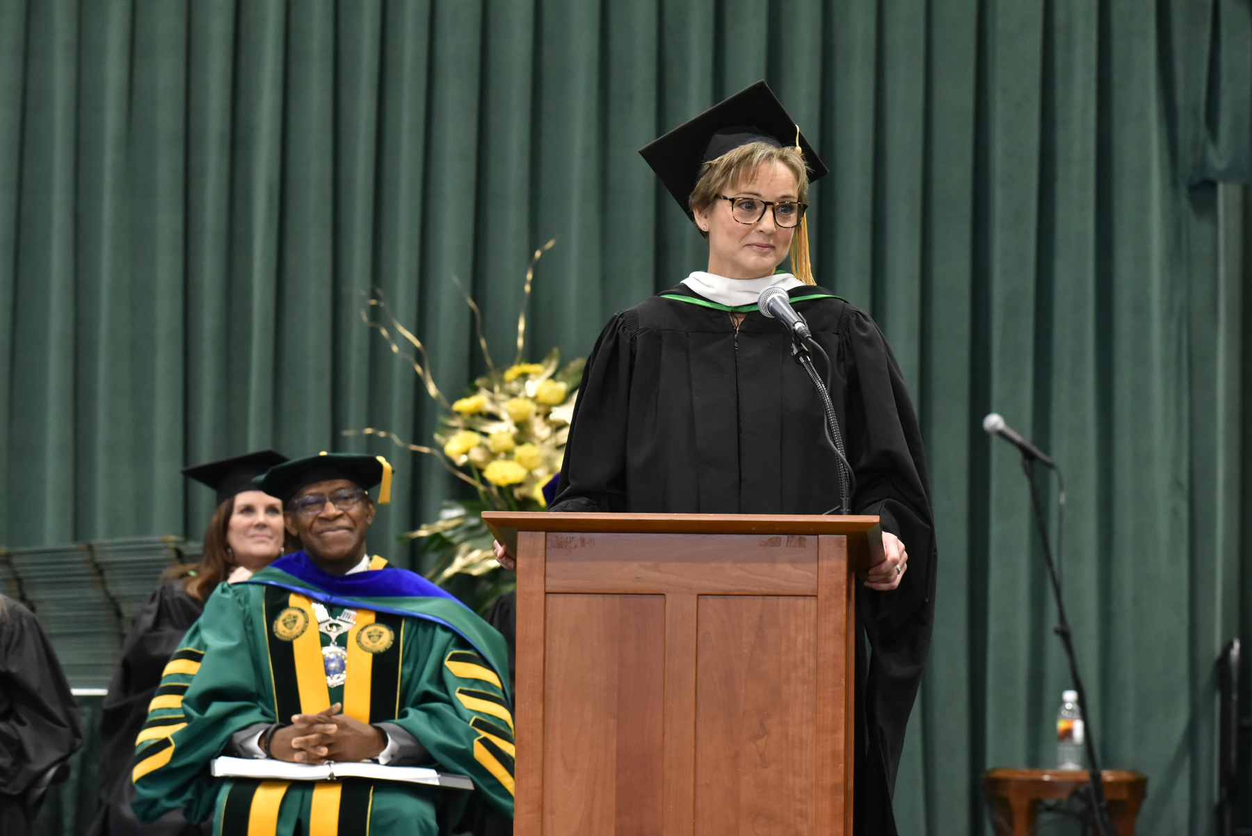 College Council member Tara FitzGibbons, a 1994 alumna of the university, greets the graduates during the Dec. 16 Commencement ceremony.