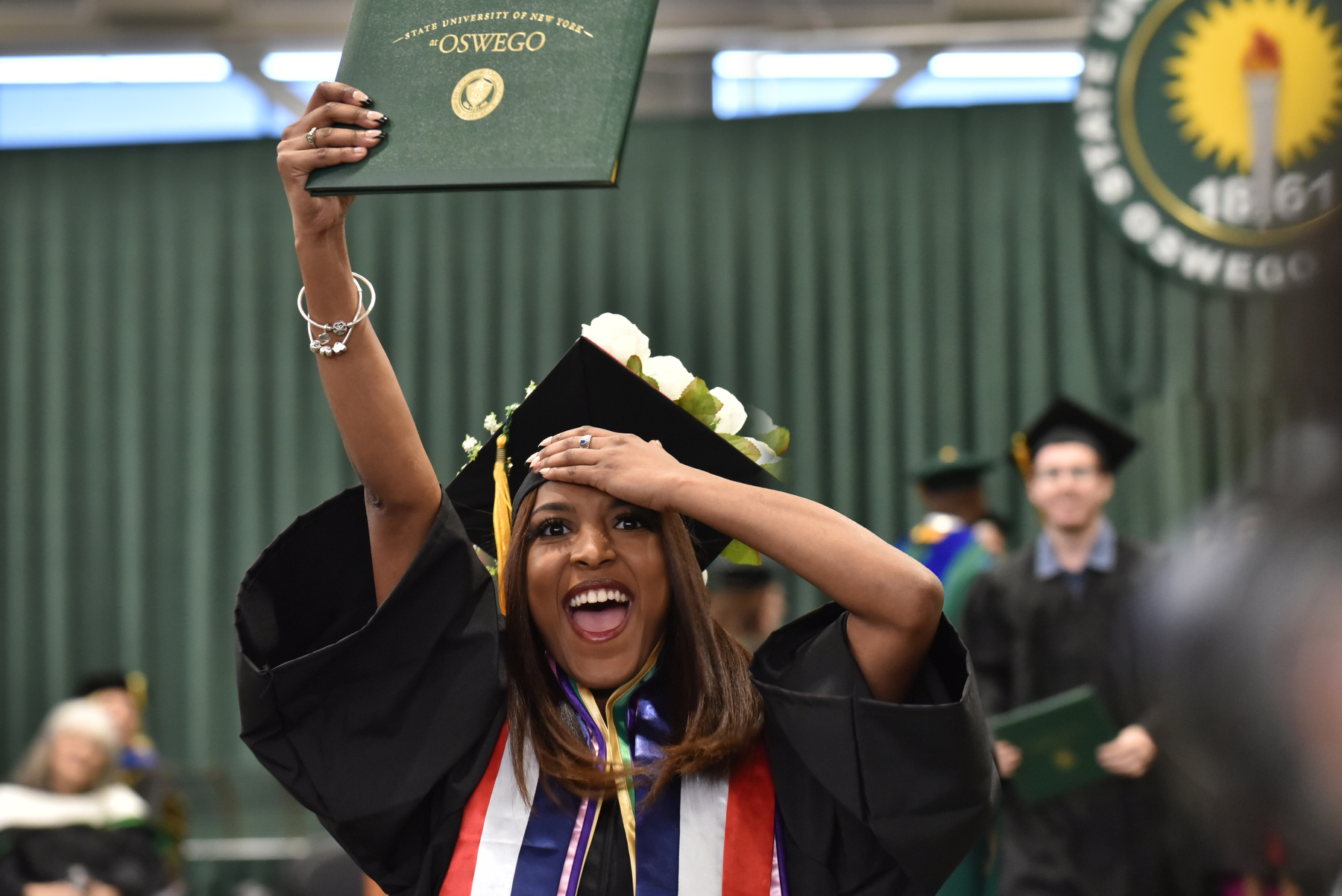 Graduates show their enthusiasm, cheered on by family members and friends in the audience at the December Commencement held Dec. 16. Each graduate's name was announced as they walked across the platform and shook hands with President Peter O. Nwosu. 