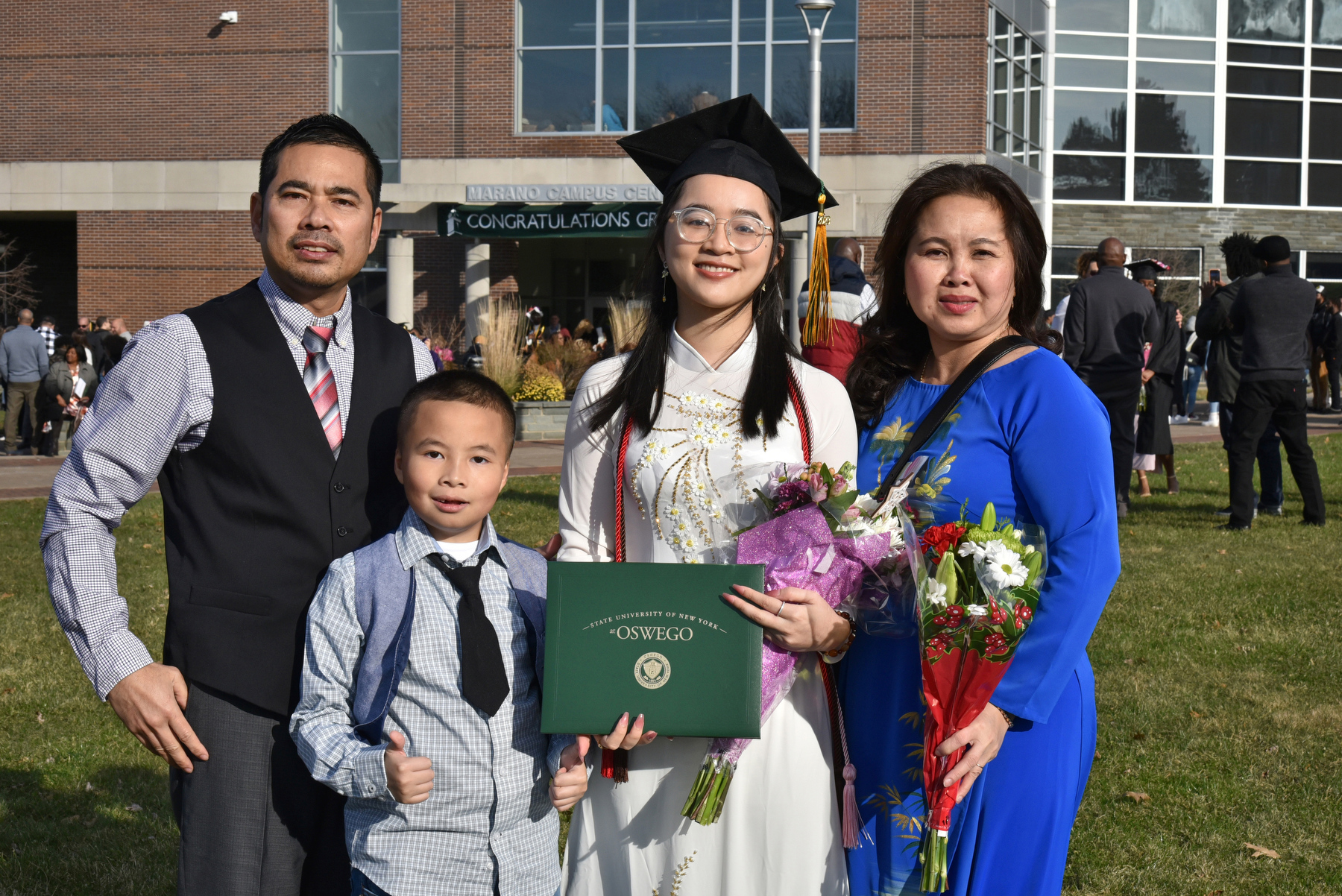Dahlia Nguyen, who earned a bachelor of fine arts in graphic design, meets with her family after the Dec. 16 graduation ceremony.