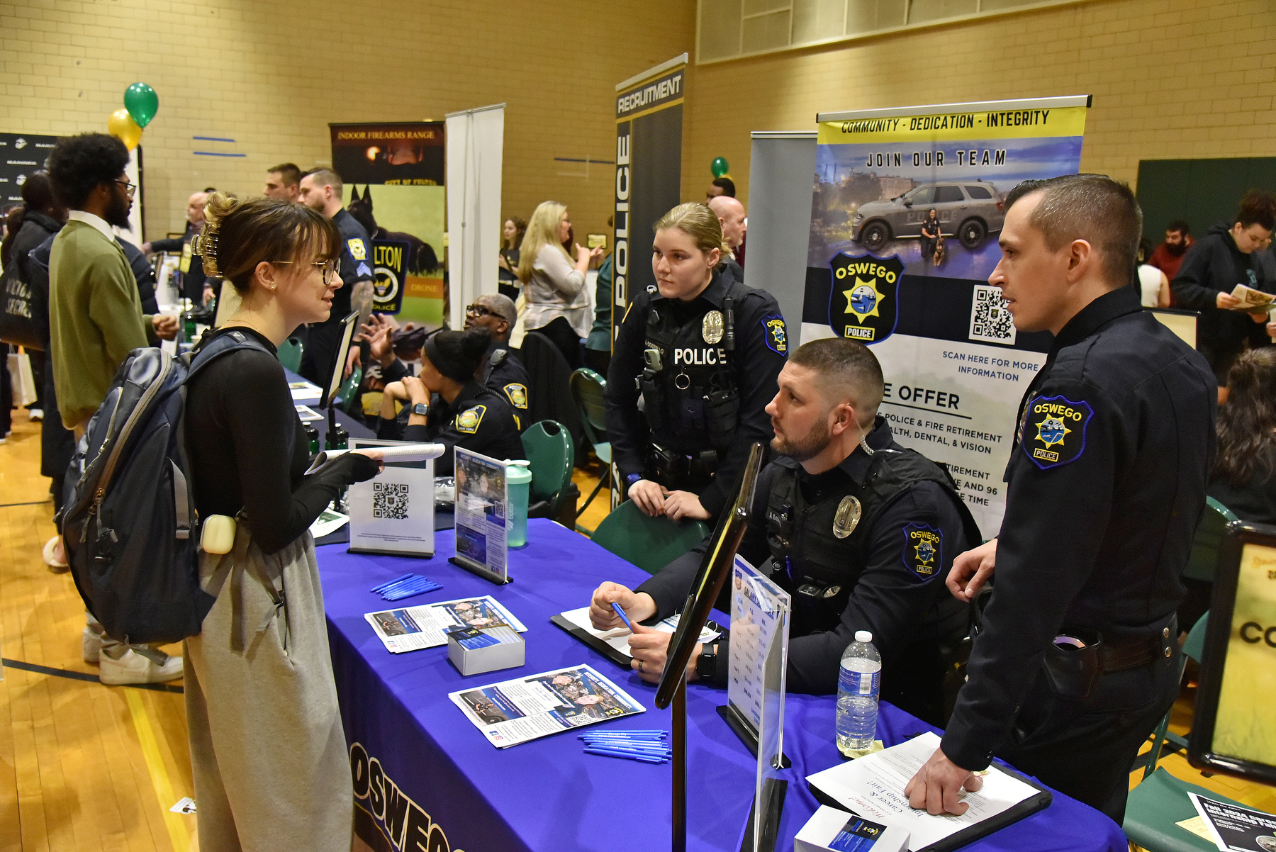Oswego students networked with over 100 employers and professionals at the Spring 2024 Career and Internship Fair. The event hosted by Career Services was held March 6 in the Swetman Gym in Marano Campus Center. Pictured, senior criminal justice major Emma Monaghan talks with Officers from the Oswego Police Department.