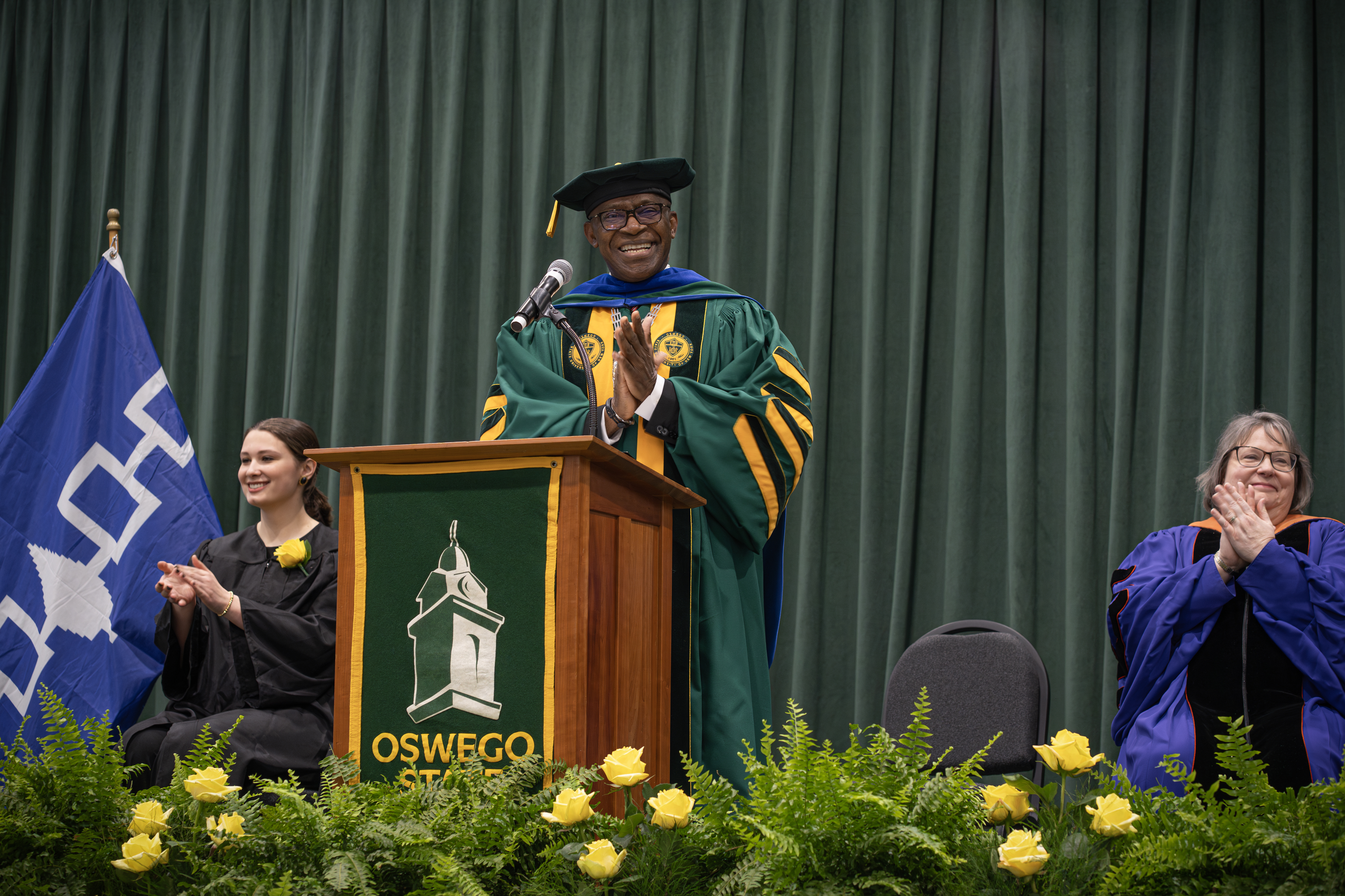 At Honors Convocation on April 19, President Peter O. Nwosu and platform party members Kylie Annable (left), president of the Vega Junior and Senior Women’s Honor Society that coordinates the ceremony, and Elizabeth Dunne Schmitt, chair of Faculty Assembly and professor of economics, applaud the more than 130 students who received awards at the ceremony as well as all those who supported these achievers.