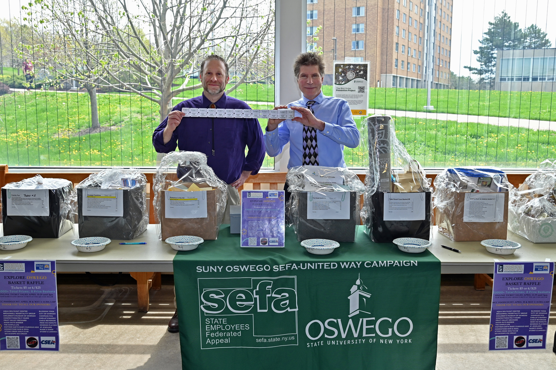 The university’s State Employees Federated Appeal (SEFA) committee recently held an Explore Oswego basket fundraiser supporting the United Way of Greater Oswego County in Marano Campus Center. Shown volunteering at the table, from left, are SEFA committee members Tim Nekritz, communications director in the Office of Communications and Marketing, and Bob Hageny, advanced technology classroom operations manager in Campus Technology Services.
