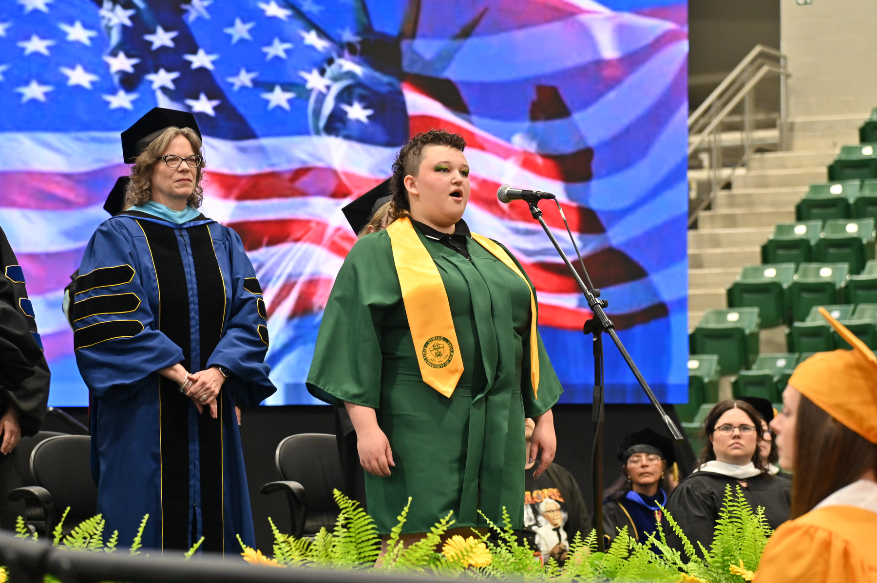 Payton Cady sings the National Anthem for the 9 a.m. College of Liberal Arts and Sciences ceremony and later for the 12:30 School of Business ceremony. Cady also led the singing of the Alma Mater at the conclusion of these two ceremonies.