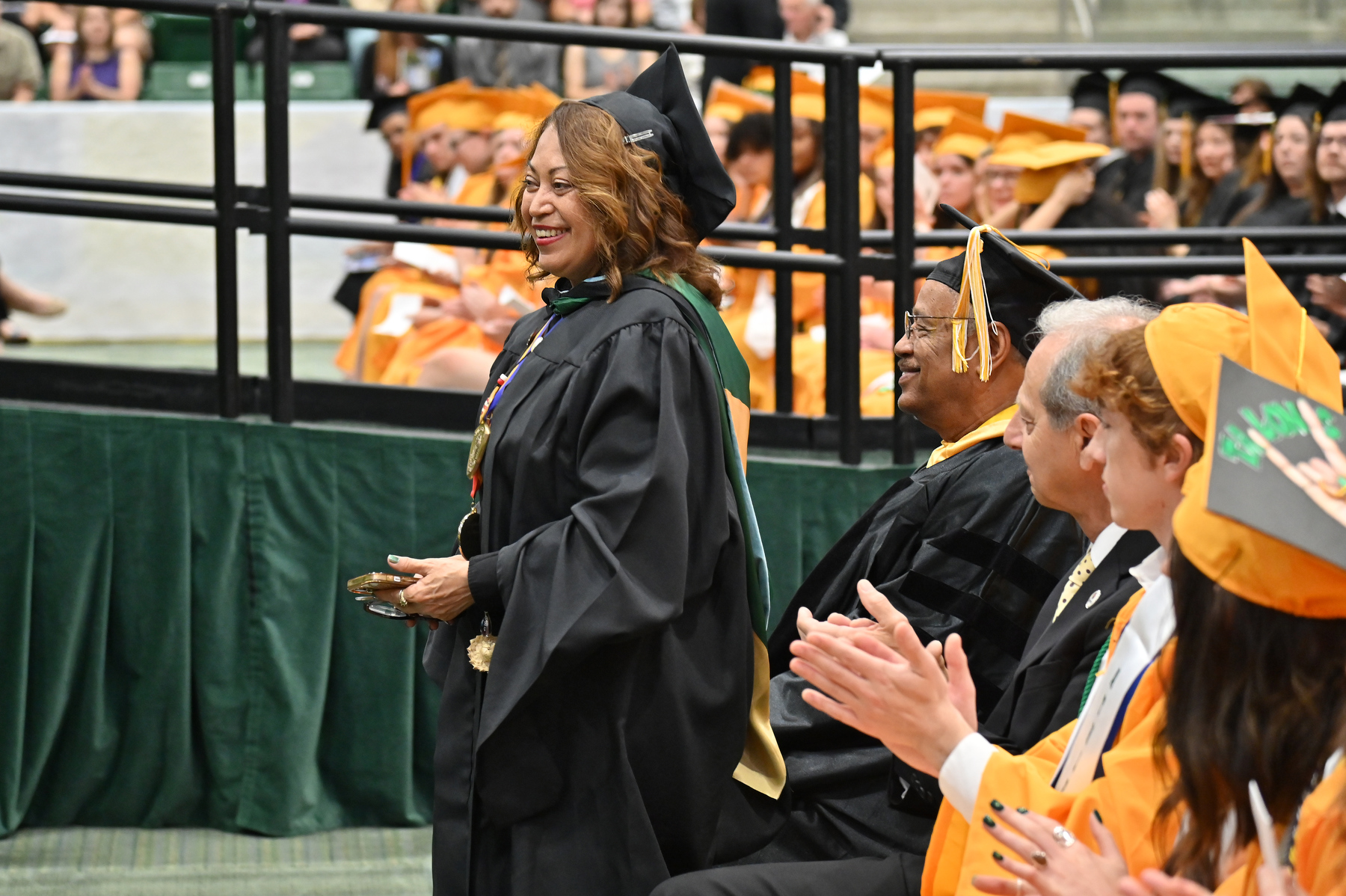 Retiring faculty and professional staff in attendance are honored. Magdalena (Maggie) Rivera, assistant dean, student outreach and support, Office of the Dean of Students; and Kamal Mohamed, professor of biological sciences and director of Rice Creek Field Station, take a bow at the 9 a.m. commencement ceremony for the College of Liberal Arts and Sciences.