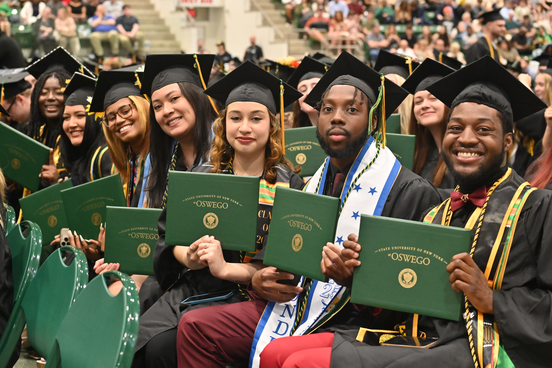 Graduates at the 9 a.m. College of Liberal Arts and Sciences ceremony proudly show their diploma covers.