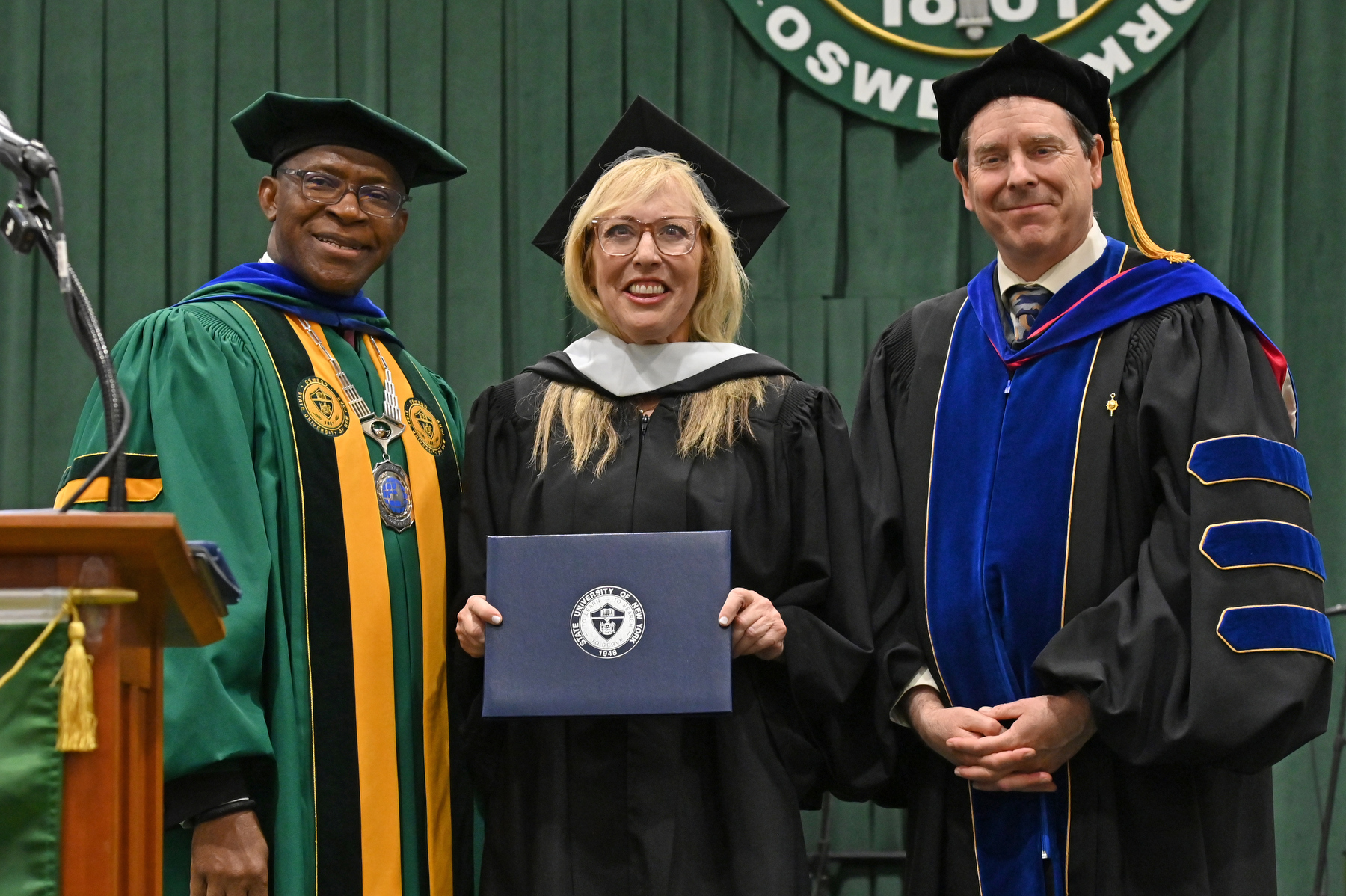 Linda Cohn of the Class of 1981, a pioneering ESPN SportsCenter anchor and Hall of Fame broadcaster, received an honorary doctor in humane letters degree during the ceremony for the School of Communication, Media and the Arts and the School of Education. Presenting is President Peter O. Nwosu and Scott Furlong, provost and vice president for academic affairs.