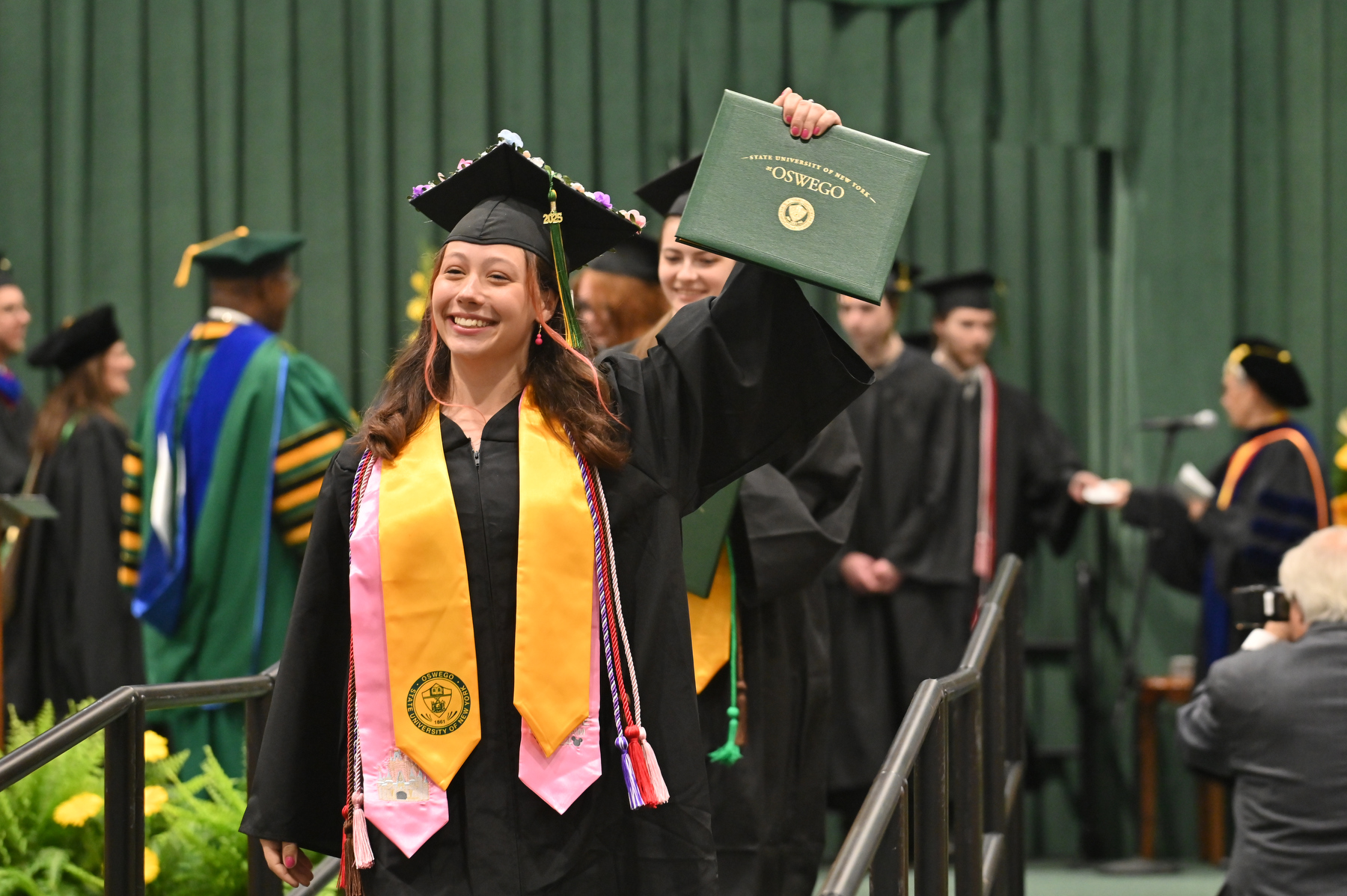 Jocelyn Decker is all smiles among the School of Communication, Media and the Arts graduates during the 4 p.m. ceremony.