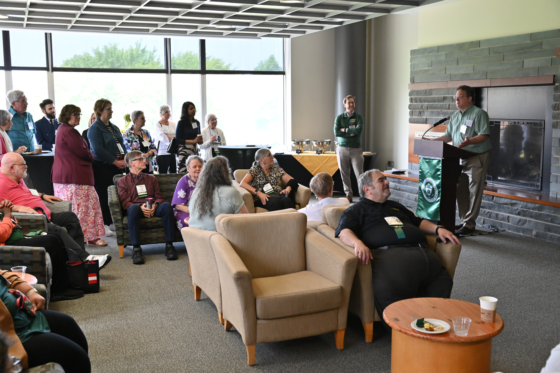 Richard Bush, technology department chair, speaks to guests at the Leadership Donor Recognition Reception in Marano Campus Center Hearth Lounge during Reunion Weekend, prior to the University Update presentation. May 2025 psychology graduate Madison Flood, and Muhammad Musozoda, who earned a bachelor’s in chemistry 2023 and a master’s in chemistry in May 2025, also spoke about their experiences at Oswego.