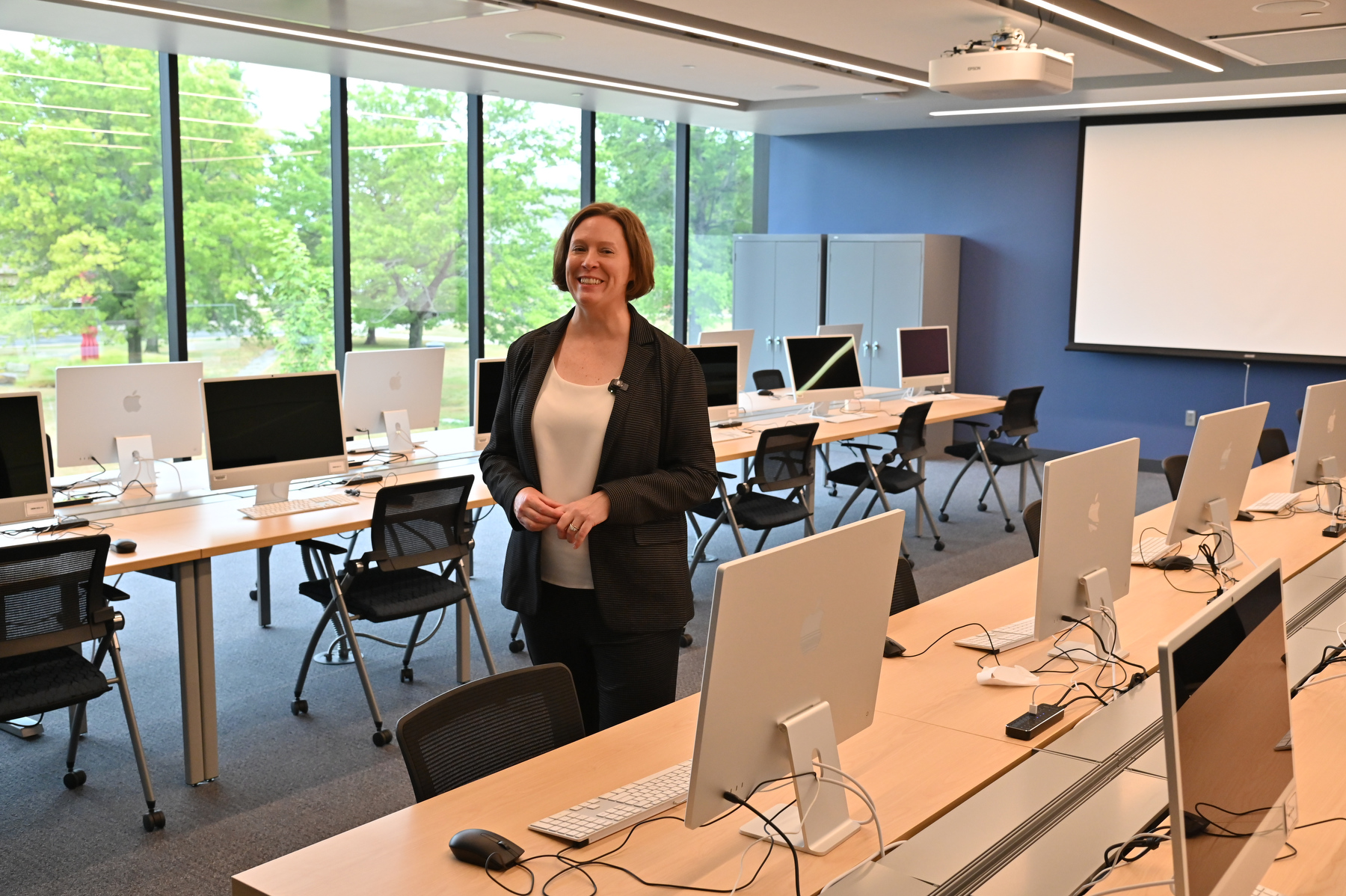 Jennifer Knapp, dean of the College of Communication, Media and the Arts, speaks to members of the media in a second-floor classroom lab which overlooks the quad between Hewitt Hall and Penfield Library during a tour of Hewitt Hall.