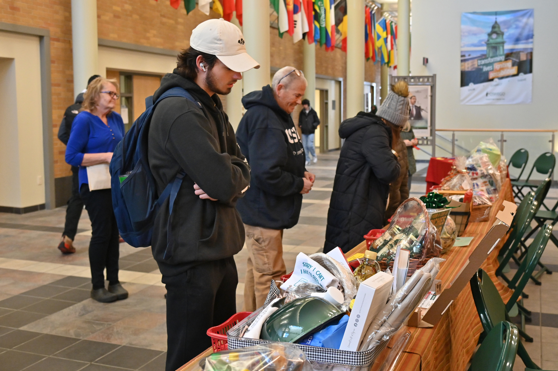 The SUNY Oswego State Employees Federated Appeal (SEFA) campaign's most popular fundraiser invited the campus community to buy chances for the Baskets of Caring raffle of creative items held Nov. 19 and 20 in the Marano Campus Center concourse. Pictured is Matthew Cicotta, a junior health promotion wellness major, Colleen DeWine of the campus grounds department, and others look over the variety of baskets.