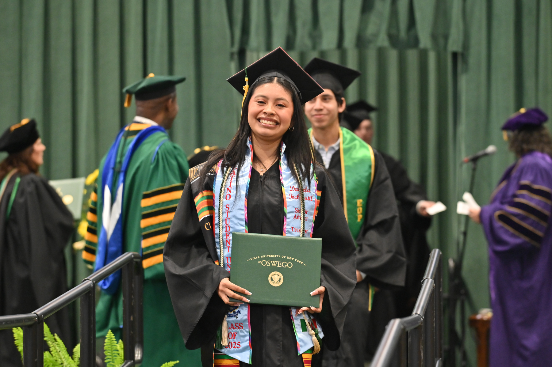 December graduate Daniela Tochihuitl beams with pride while walking from the platform.