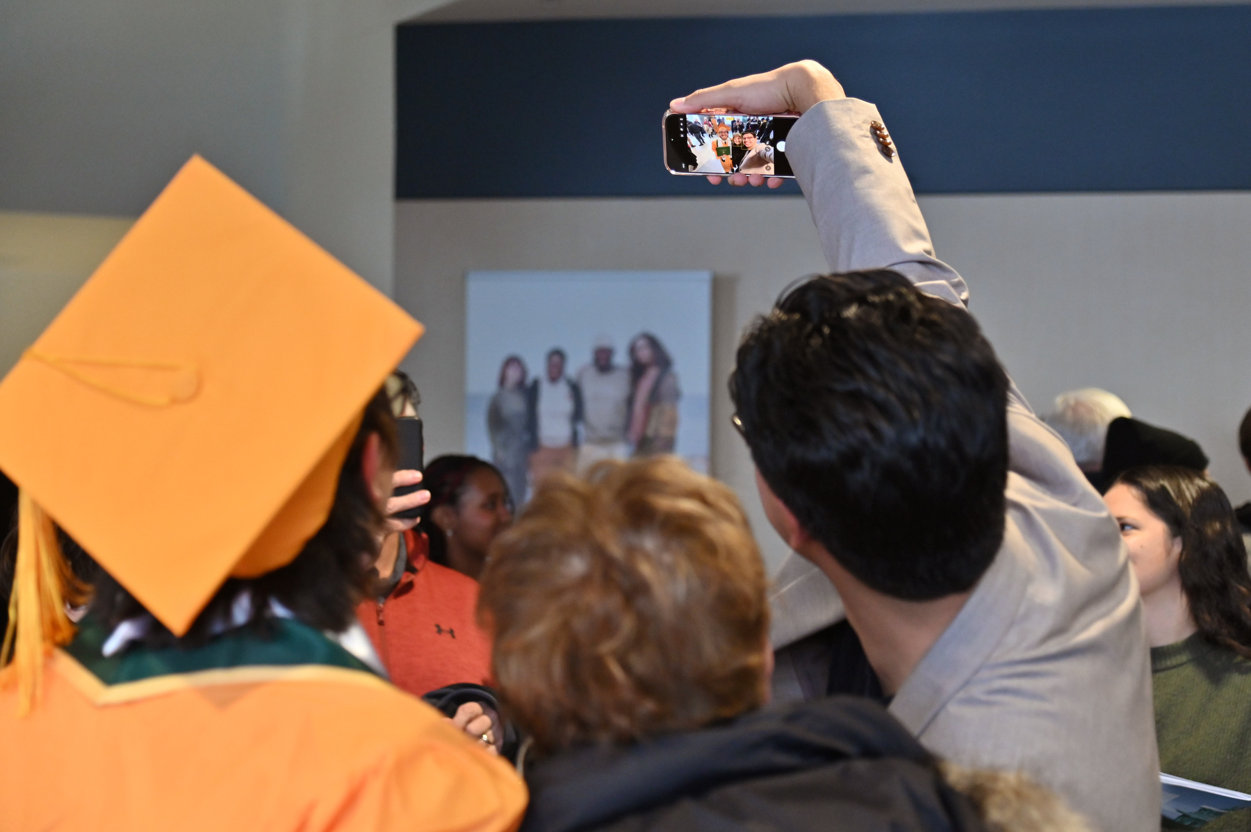 Zachary DeMott (left) of Oswego, a summa cum laude graduate in wellness management, poses for a selfie taken by his brother Austin with friends after the ceremony.
