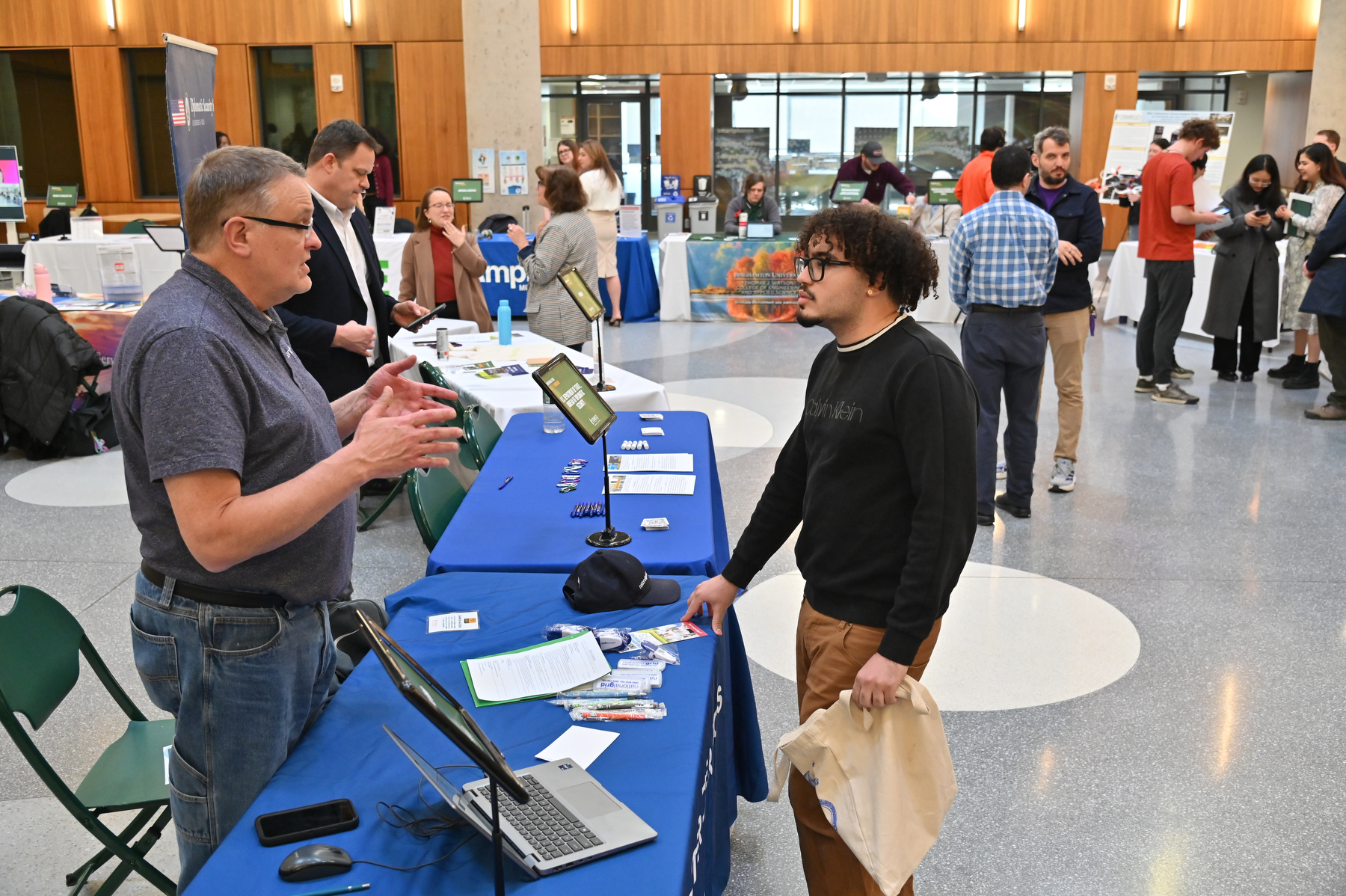 At the Engineering Industry Showcase, April 8 in the Shineman Center Nucleus, junior computer science major Danny Germosen, talks with Jim Dillon, a National Grid Engineer. The networking showcase is an annual highlight of SUNY Oswego’s Engineering Week, sponsored by Micron Technology.