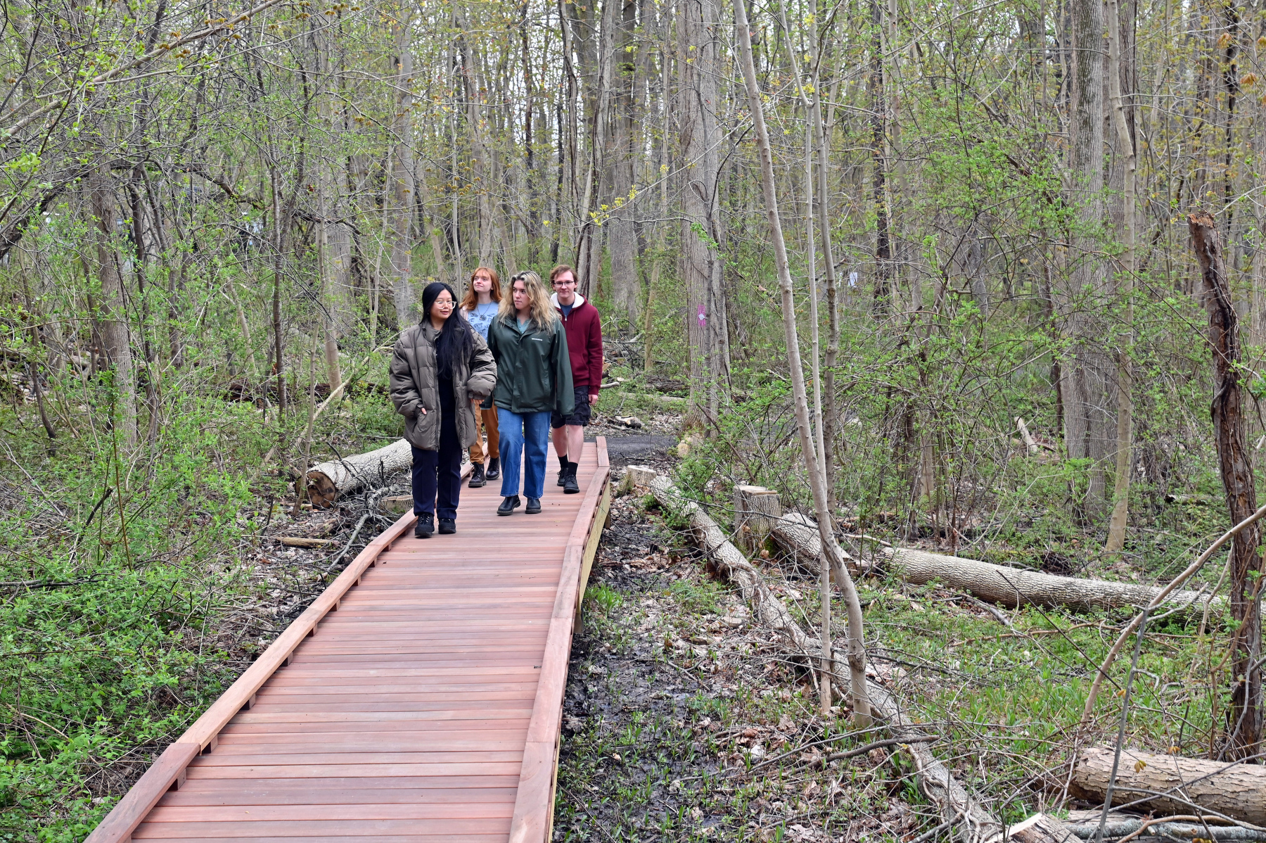 Rice Creek Field Station's new accessible Purple Trail officially opened with a April 30 Grand Opening ribbon cutting ceremony and celebration on April 30. Pictured are students walking along a section of the new trail with attractions including QR-code signs designed by student Julia Ryan spaced along the trail to help visitors learn about amphibians and reptiles that are native to Rice Creek. Visitors also can see a picture book while on the trail, thanks to Oswego Public Library's Story Walk installation