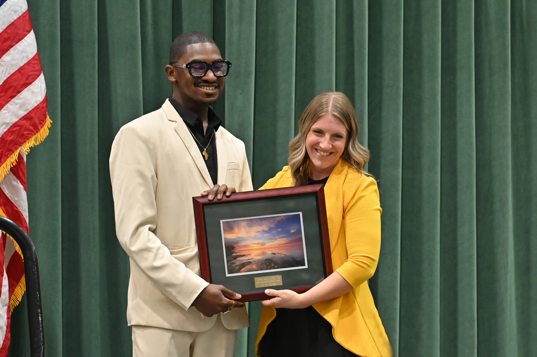The Commencement Eve Reception featured Jamal Akin-Tukur receiving the Outstanding Senior Award, presented during the ceremony for the graduating seniors and their families in the Deborah F. Stanley Arena and Convocation Hall. Presenting the award is Laura Pavlus Kelly, a 2009 graduate and executive director of the Oswego Alumni Association and director of alumni engagement.