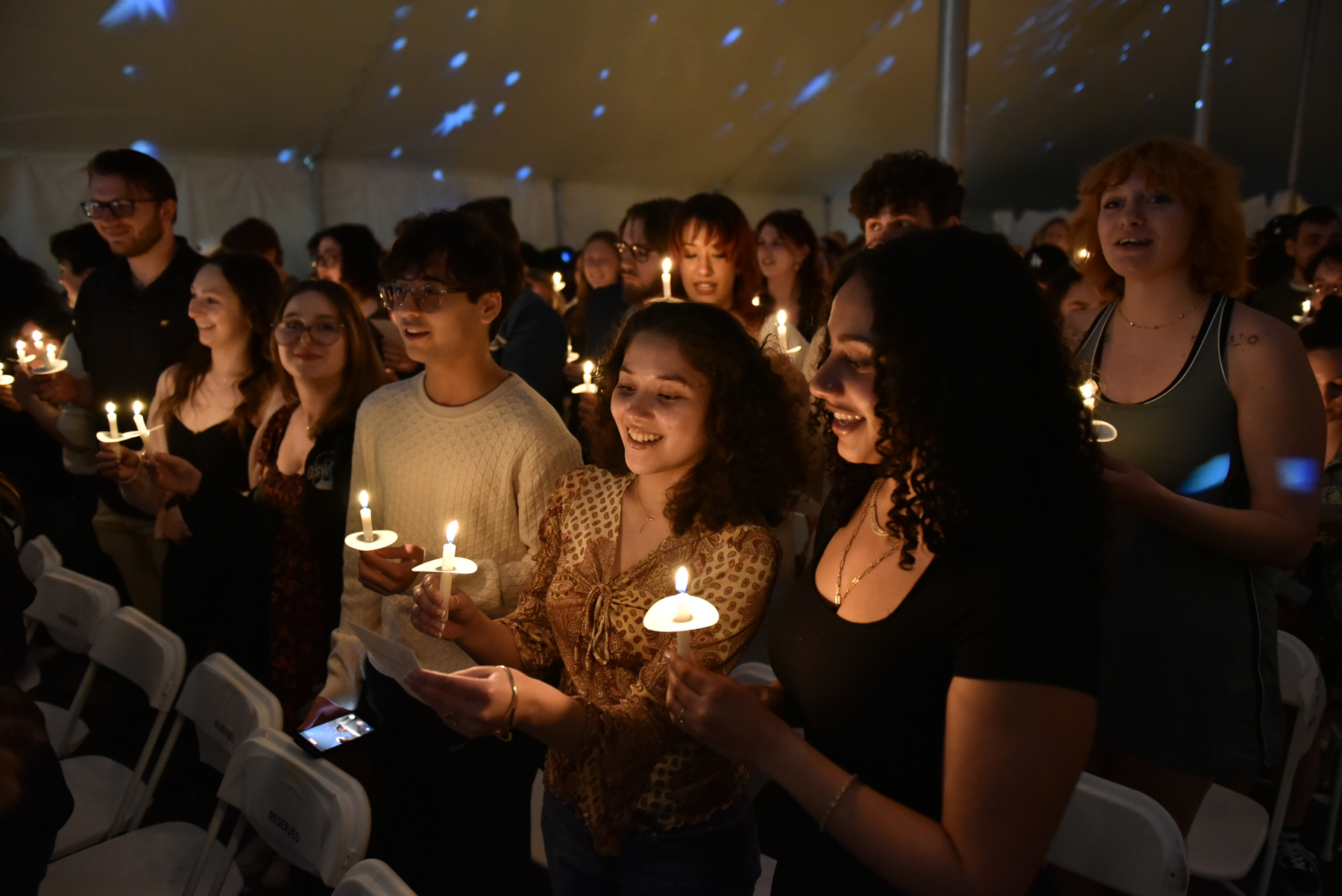 Graduates and families hold candles during the Commencement Eve Torchlight Ceremony.