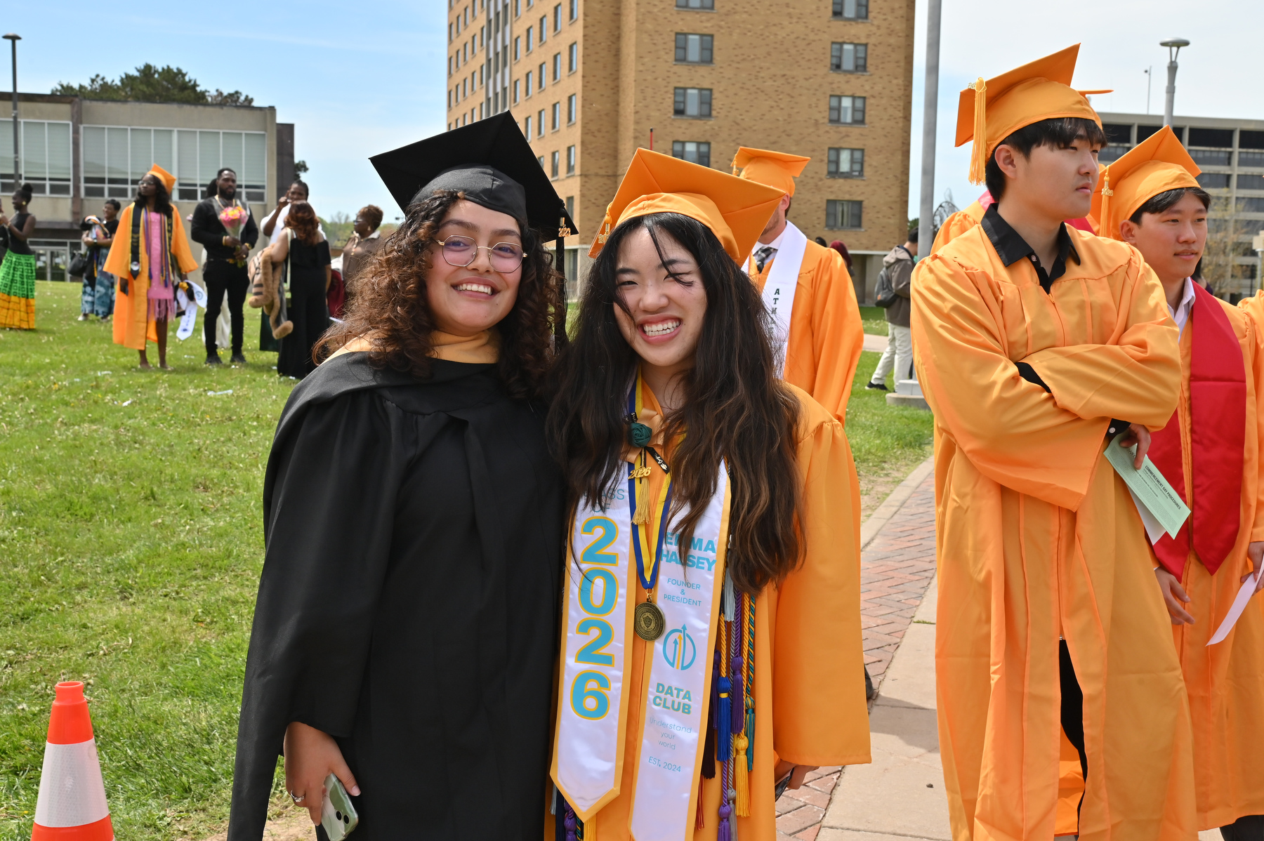 April Lopez (left), assistant dean of students, and graduating senior Emma Halsey, a double major in business administration and information science and a recipient of the SUNY Chancellor’s Award for Student Excellence, gather at the entrance to Marano Campus Center before the 12:30 p.m. commencement ceremony for the College of Business and Entrepreneurship.