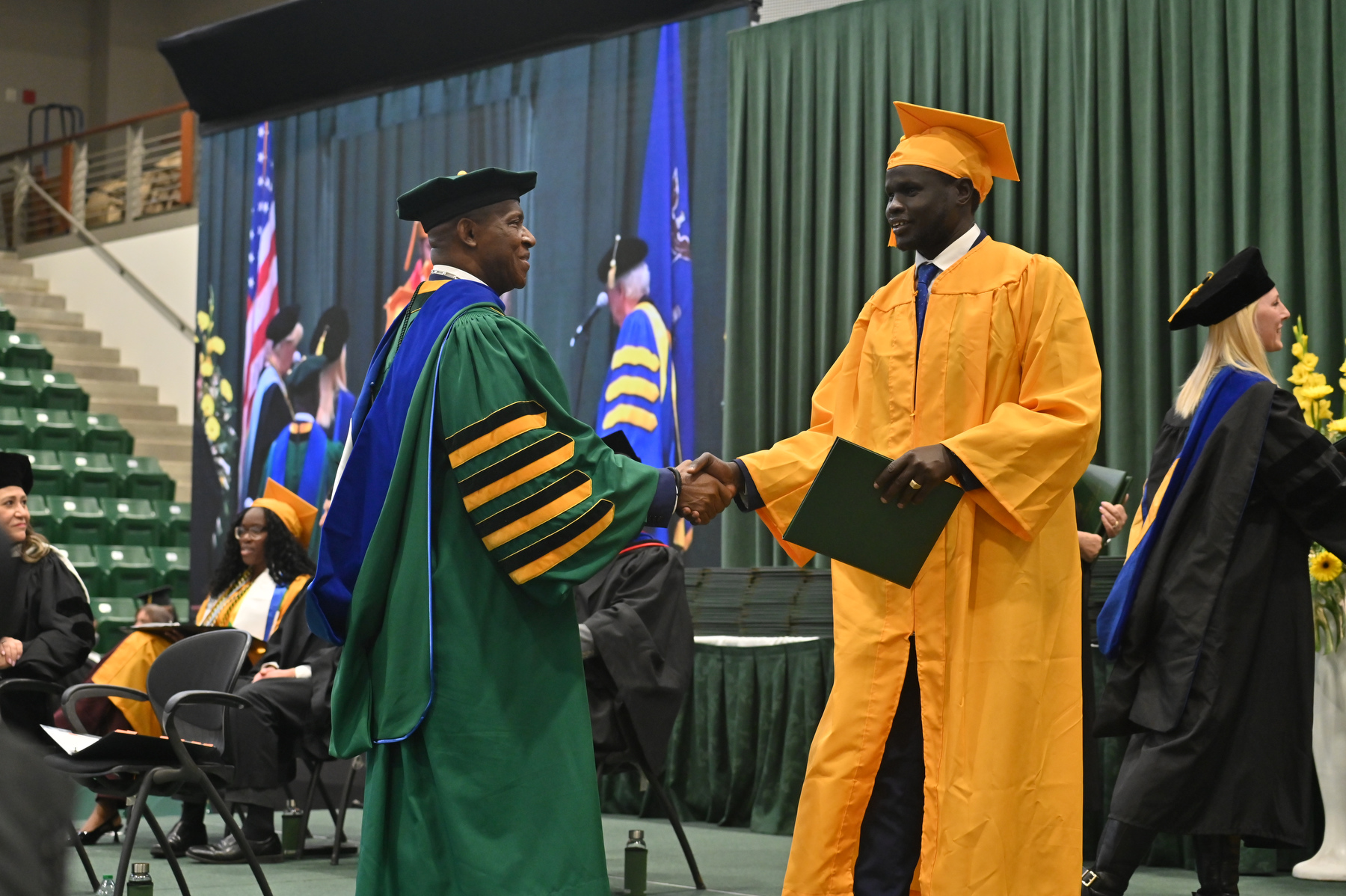 President Peter O. Nwosu congratulated each graduate as they walked across the platform, including here at the 12:30 p.m. ceremony for the College of Business and Entrepreneurship.