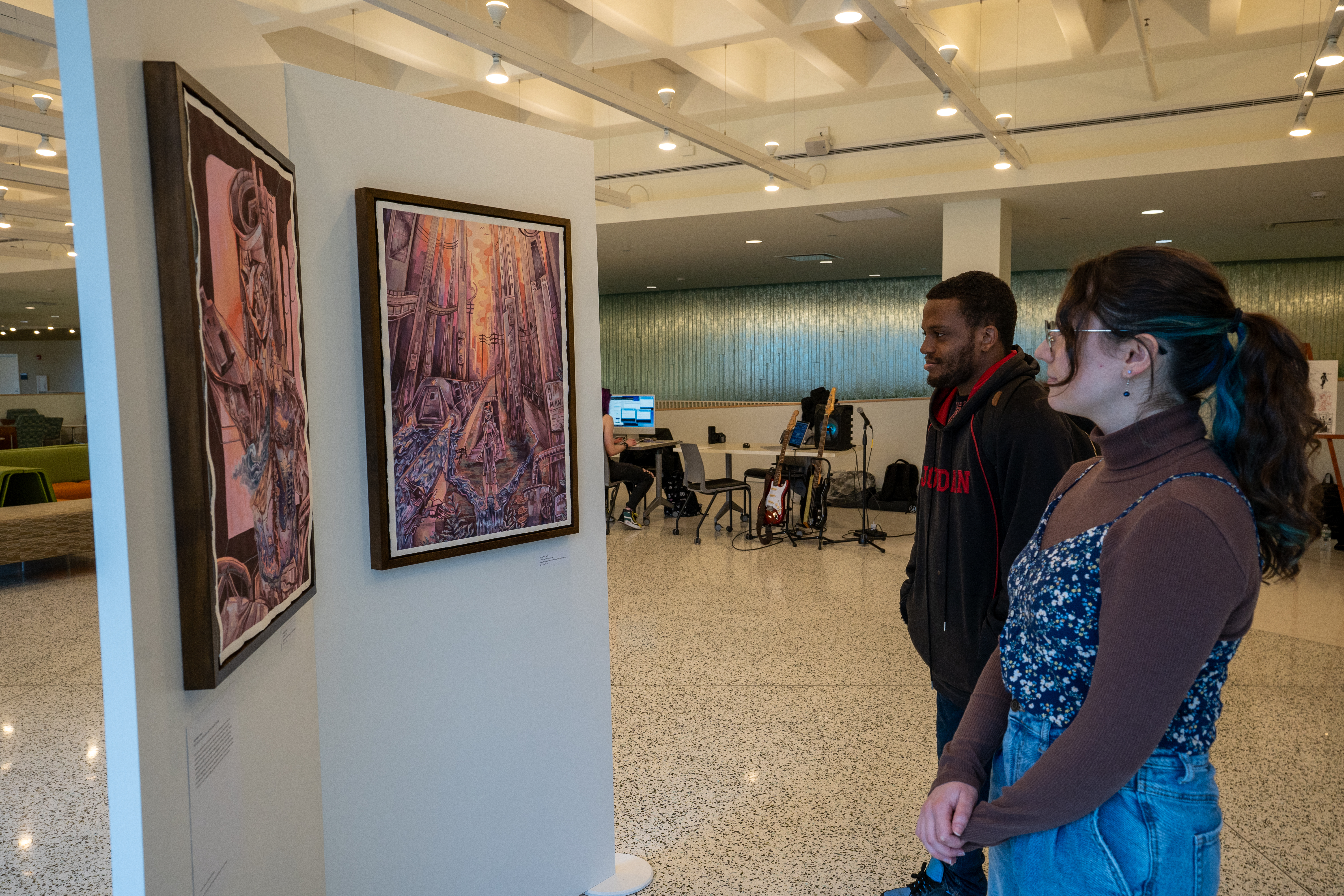 Andrienne Licata (right), a bachelor of fine arts studio art/illustration major, also majoring in creative writing, displayed some recent illustrations in the Tyler Hall lobby during Quest.