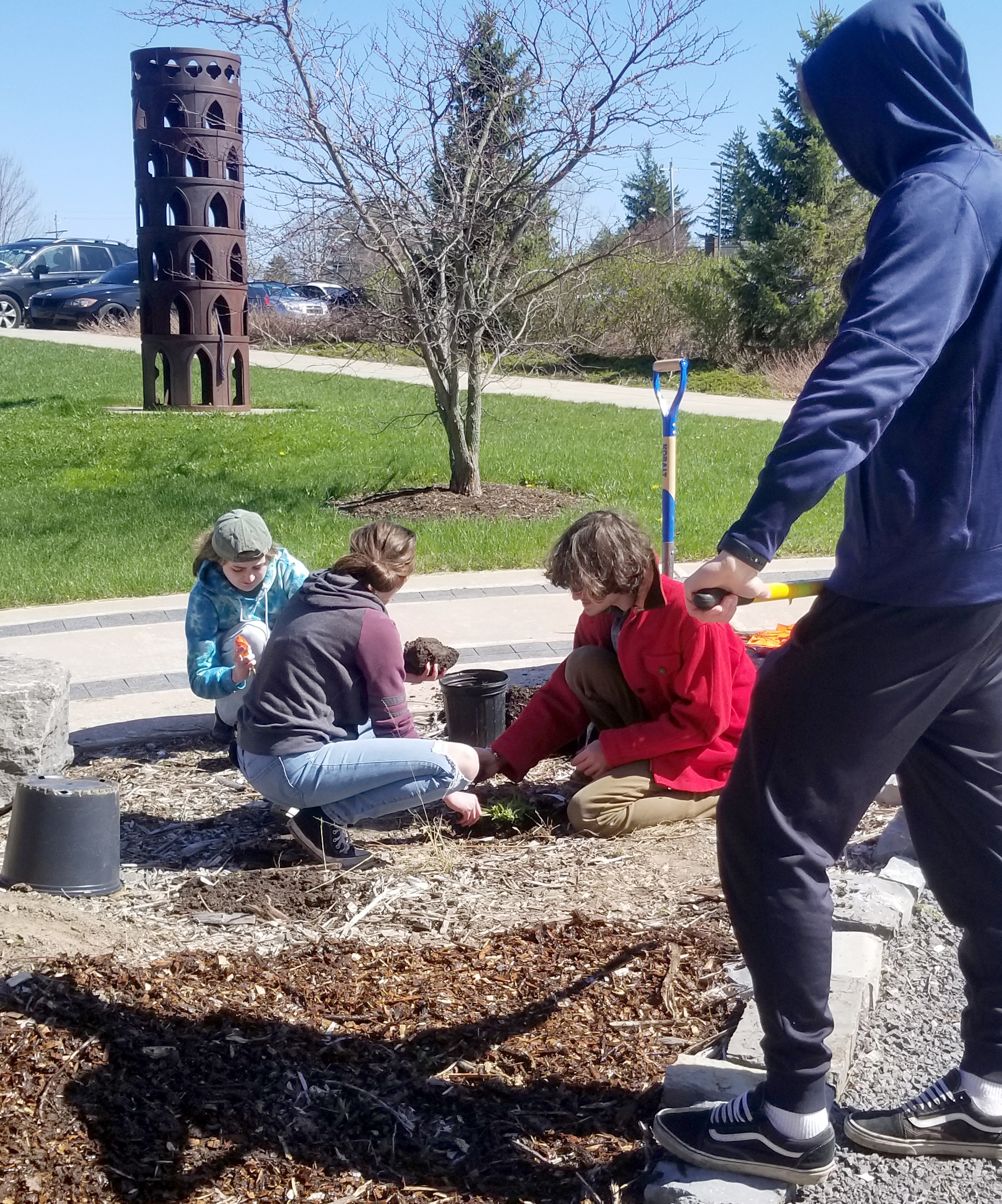 Students from biological sciences faculty member Eric Hellquist's BIO 320: Introductory Ecology work on the alvar native plant garden beds in front of the Shineman Center. 