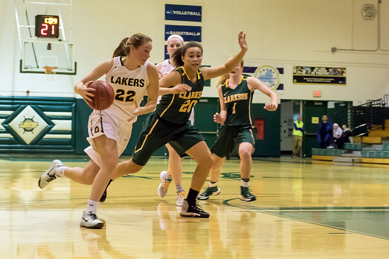 Courtney Ameele drives toward the basket in a women's basketball game