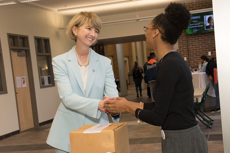 Chancellor Kristina M. Johnson greets senior human development major Deniela Mejia