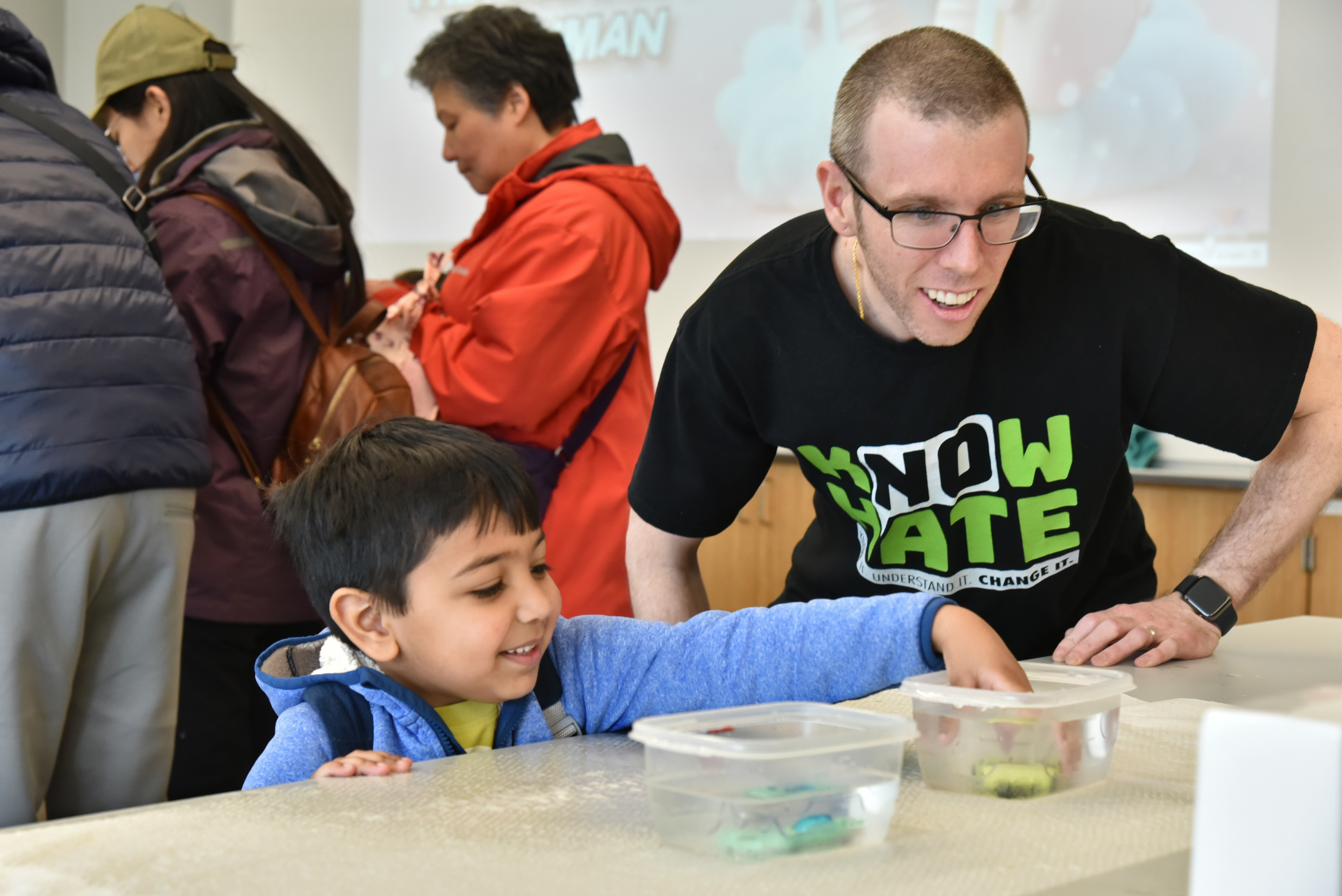 Thomas Brown, a faculty member in the Chemistry Department, helps demonstrate to young visitors thermochromic color-changing coatings on various objects, which change color at different temperatures. This was one of many family-friendly science-based activities taking part in the Shineman Center both during the day of the eclipse (pictured) as well as STEM Community Day on April 6.