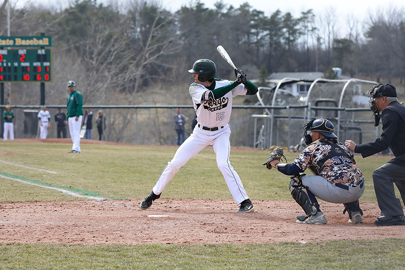 Oswego baseball player Michael Dellicari bats, striding into a pitch