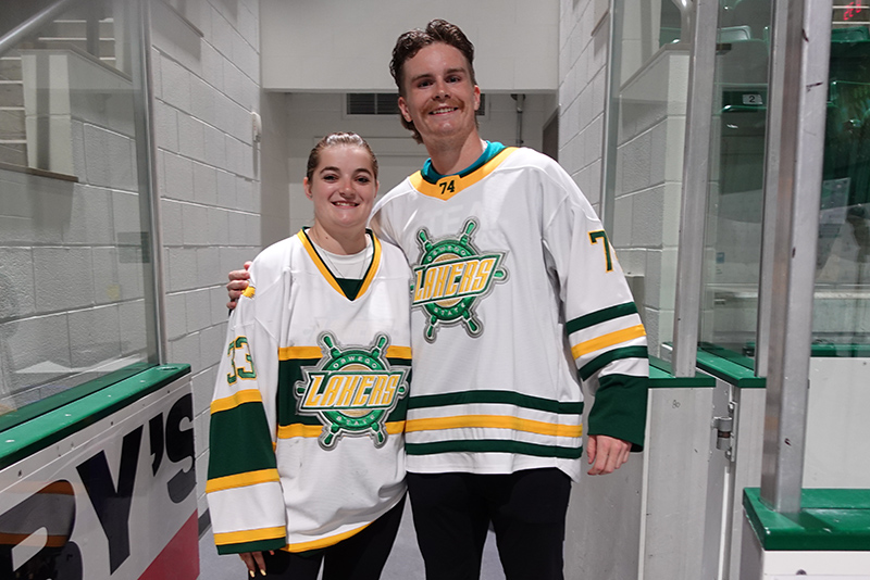 SUNY Oswego women's and men's hockey player pose at Whiteout night before hyping up the crowd