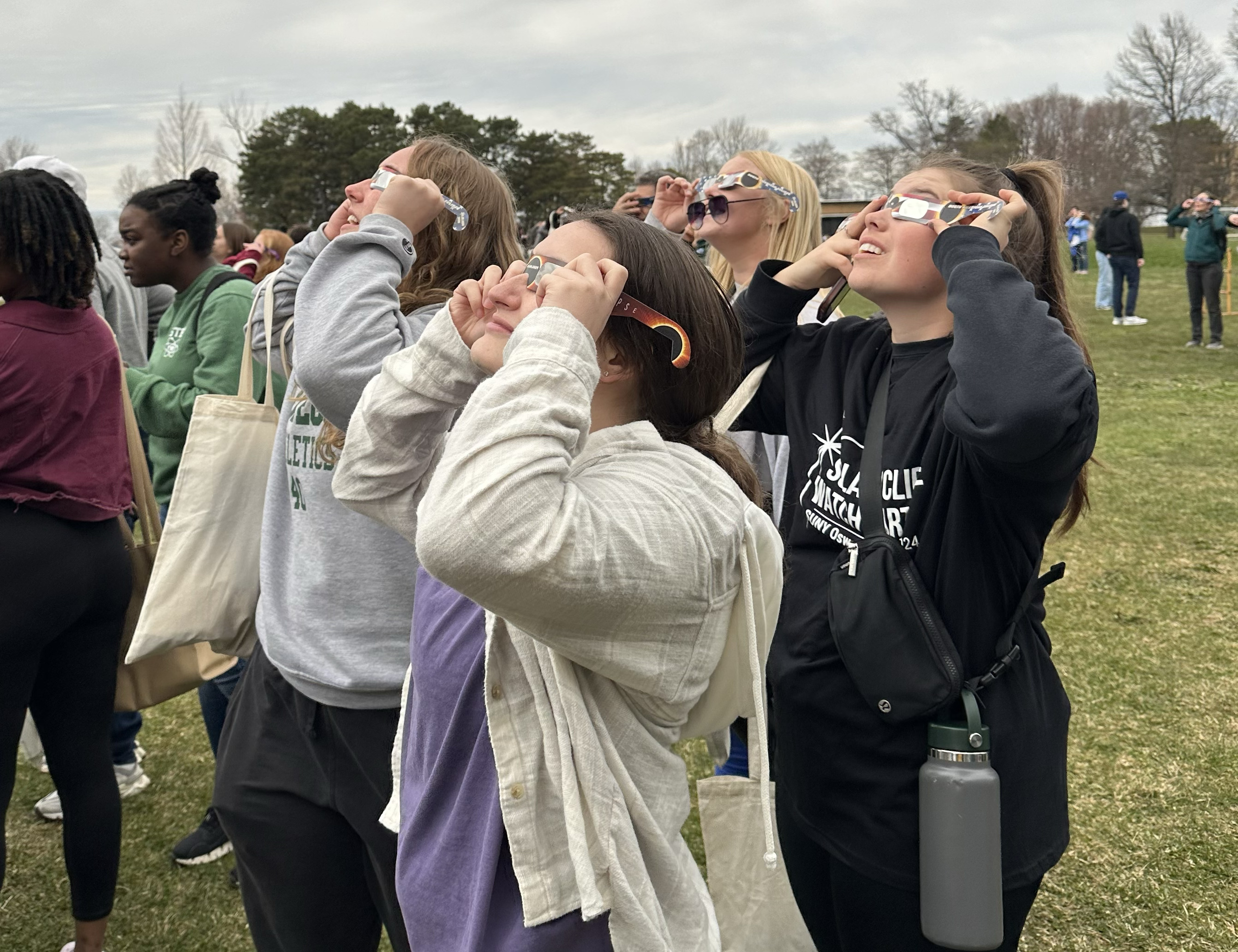 Students look up at the eclipse using their approved safety glasses.