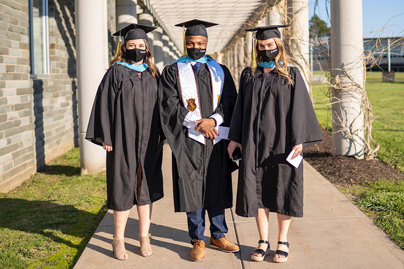 Three master's candidates arrive for the Friday, May 14, ceremony for graduate students and others earning their advanced degrees and certificates.