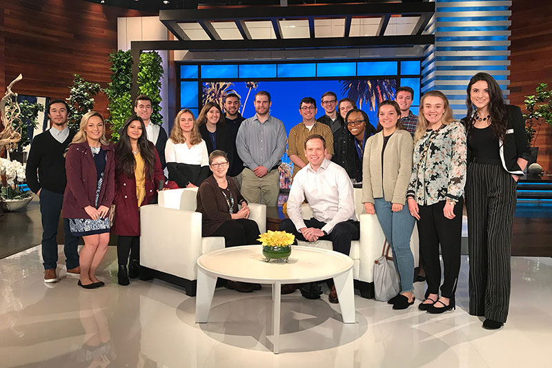 Students the college’s annual Hollywood P.O.V. program gather around adviser on set of Ellen show