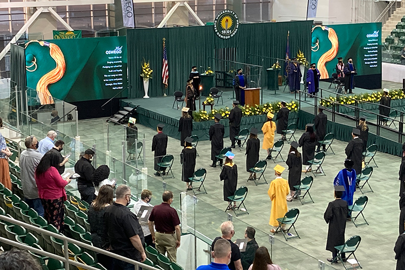 Participants and attendees stand during Commencement ceremonies to sing the college's alma mater.