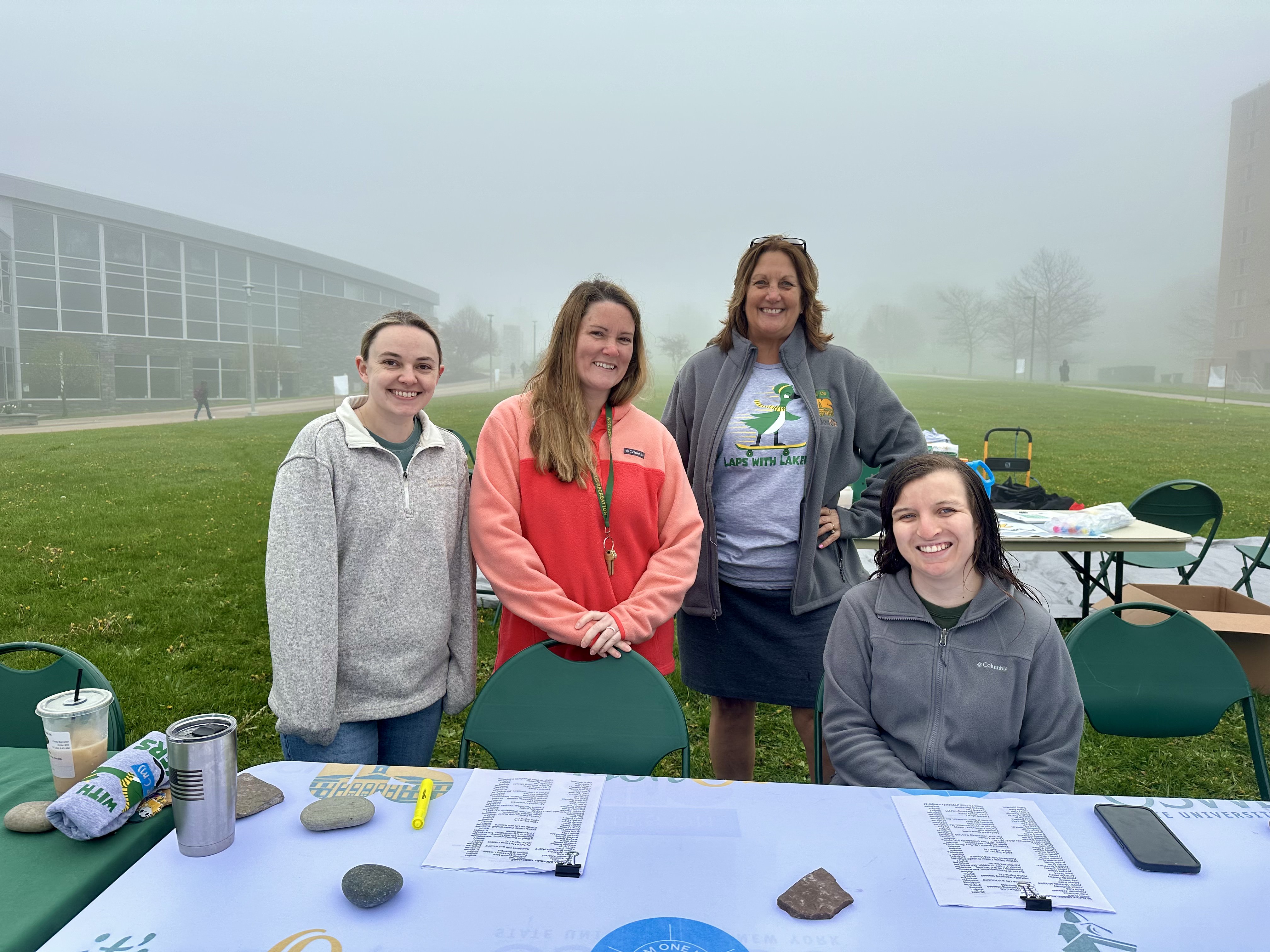 Organizers and volunteers for Laps with Lakers work the table for the event outside Marano Campus Center on the foggy morning on May 1. Laps with Lakers aims to raise awareness of sexual and interpersonal violence by challenging the campus community to walk or run laps around Academic Quad.