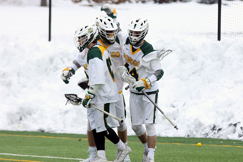 The Oswego State men's lacrosse team celebrates a goal