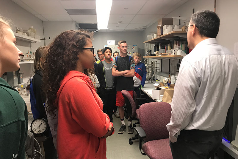 Chemistry faculty member and department chair Fehmi Damkaci (right) speaks with some of the Oswego Middle School students