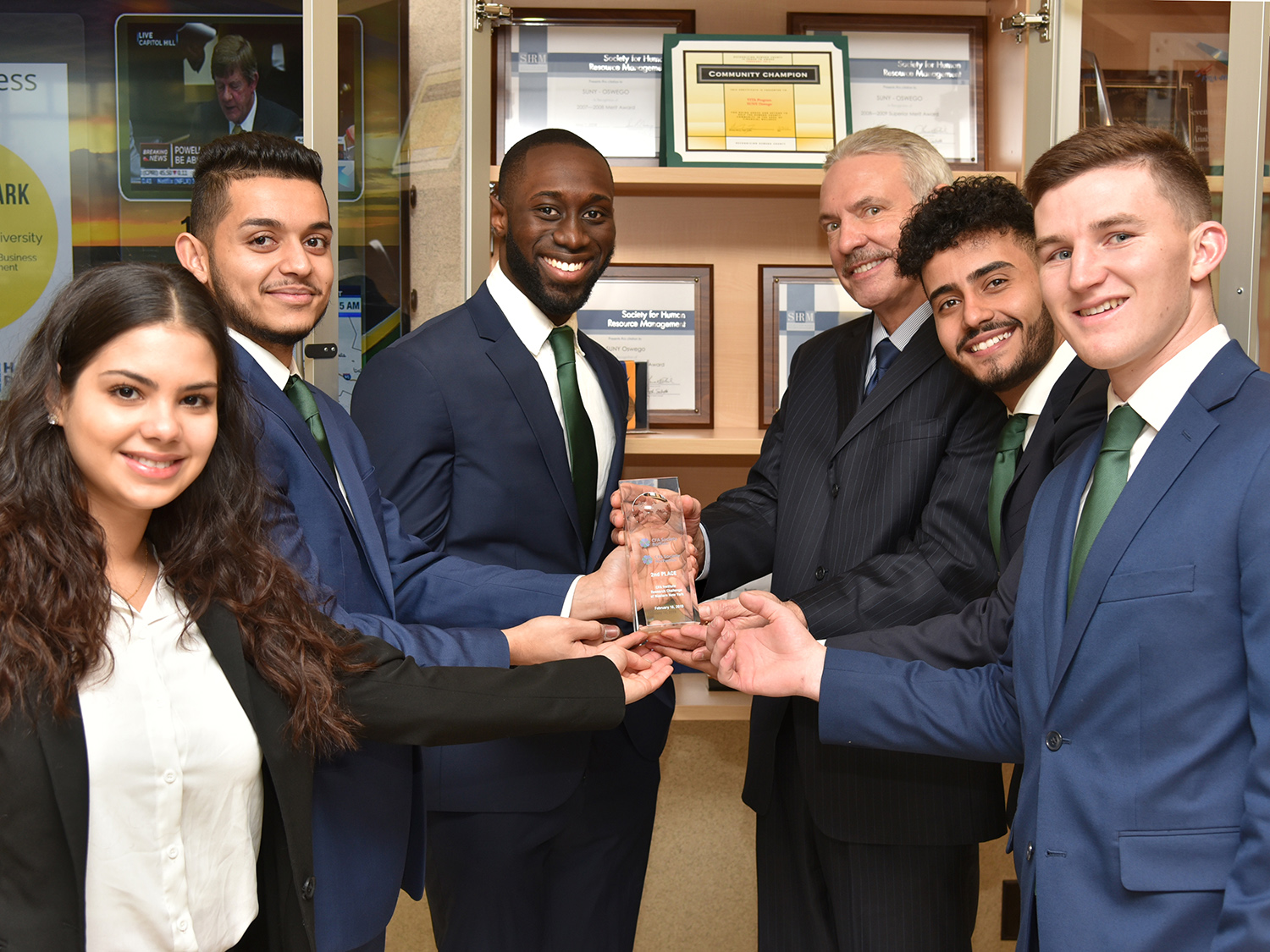 Students who placed in CFA challenge present Dean of Business Richard Skolnik with trophy