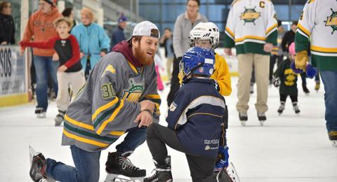 Cedric Hansen of the Laker men's hockey team talks with young skaters