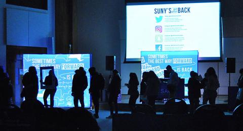 Silhouetted students work on filling bags in the SUNY's Got Your Back event