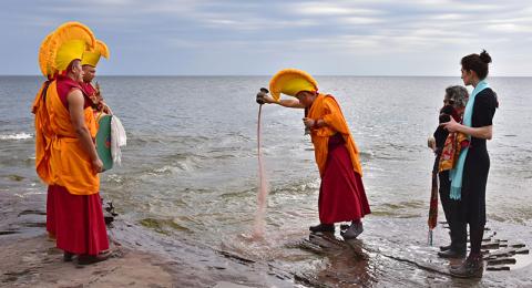 A Drepung Loseling monk pours colored sand into Lake Ontario as part of the closing ceremony of "The Mystical Arts of Tibet"