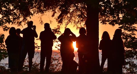 Alumni take photos of sunset over Lake Ontario