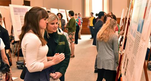 Charlotte Labrie-Cleary explains her chemistry research to Kristen Eichhorn