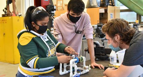 Working on a class assignment project that incorporates floating vehicle buoyancy, hydraulics, pumps and battery powered motors are (from left) junior technology education majors Shafia Ibrahim, Hunter Sabella and Ryan Parrish. 